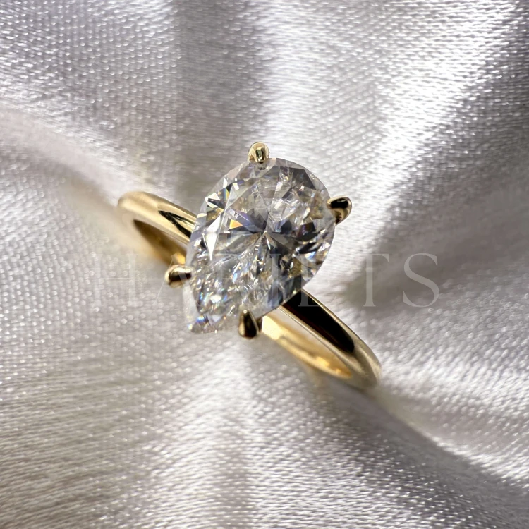 bague-de-fiançailles-solitaire-lumiere-moissanite-1-5ct-poire-or-jaune-gros-plan-face-hariets.jpg