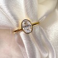 bague-de-fiancailles-bezel-moissanite-0-5ct-taille-ovale-gros-plan-or-jaune-pure-hariets.jpg