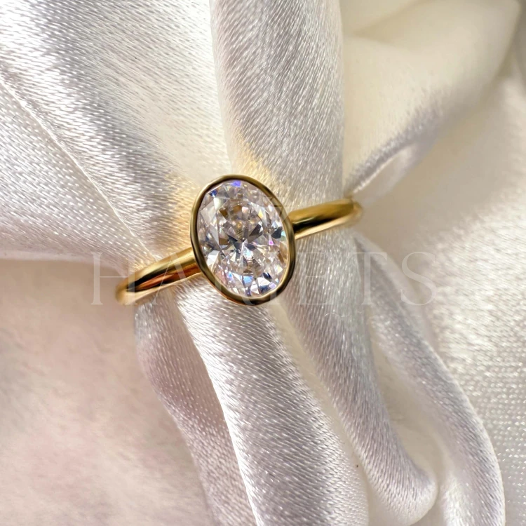 bague-de-fiancailles-bezel-moissanite-0-5ct-taille-ovale-gros-plan-or-jaune-pure-hariets.jpg