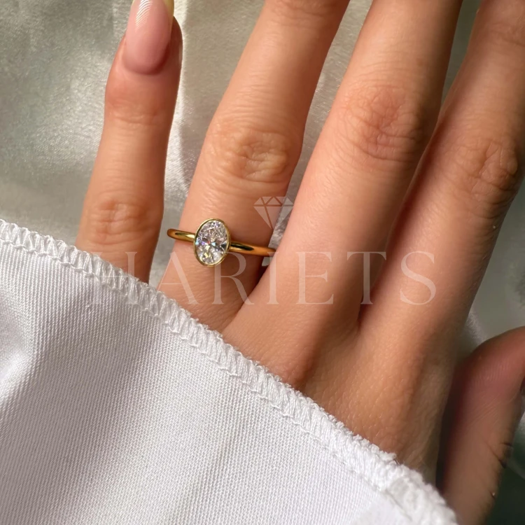 bague-de-fiancailles-bezel-moissanite-0-5ct-taille-ovale-au-doigt-or-jaune-pure-hariets.jpg