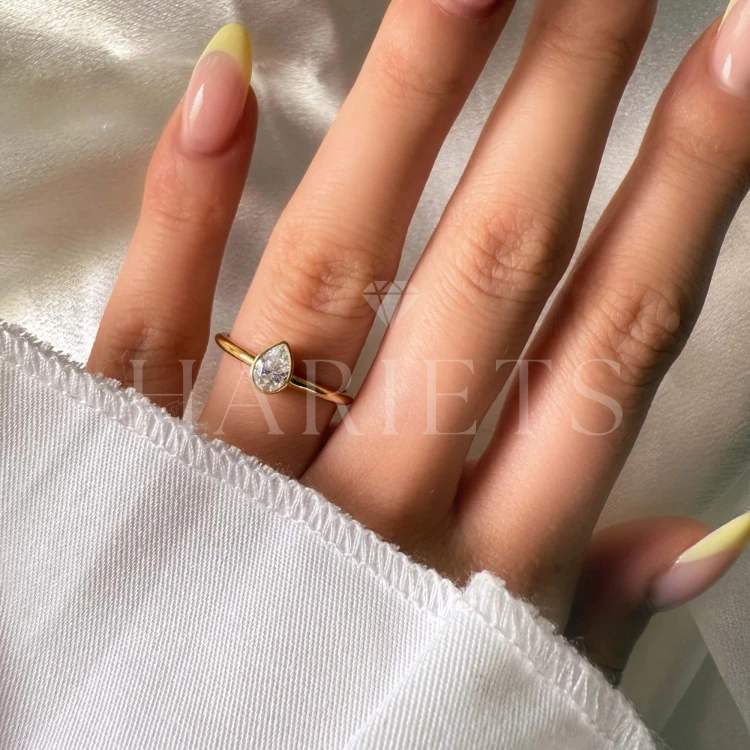 bague-de-fiancailles-bezel-moissanite-0-5ct-taille-poire-au-doigt-or-jaune-drop-hariets.jpg