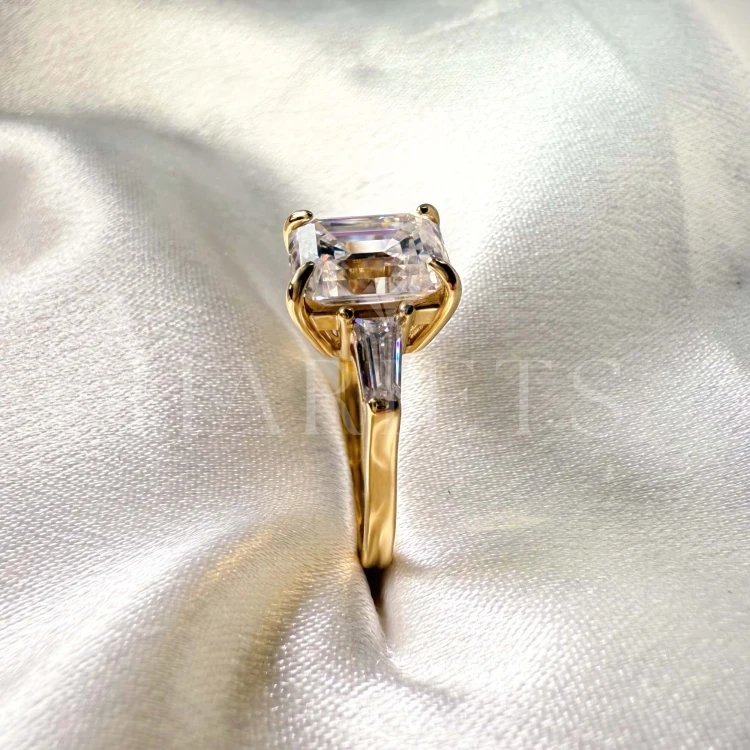 bague-fiancailles-trinity-moissanite-4ct-taille-émeraude-gros-plan-cote-or-jaune-florence-hariets.