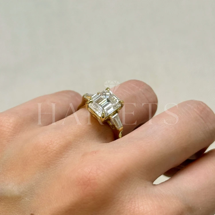 bague-fiancailles-trinity-moissanite-4ct-taille-émeraude-cote-sur-doigt-or-jaune-florence-hariets.