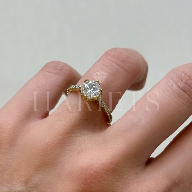 bague-fiancailles-halo-flora-moissanite-1_5ct-taille-brillant-cote-face-sur-doigt-or-jaune-hariets.jpg