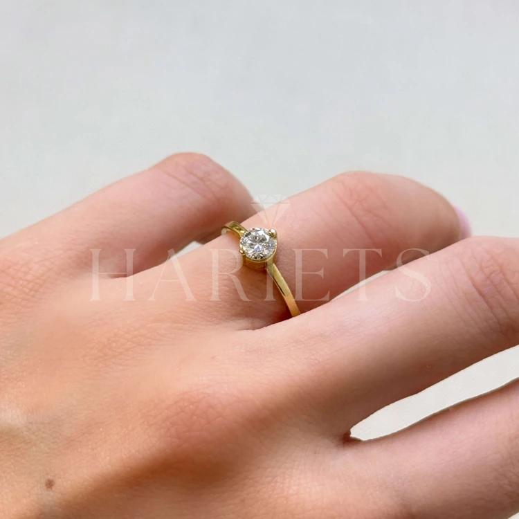 bague-fiancailles-petit-moissanite-0-5ct-taille-brillant-au-doigt-cote-or-jaune-enigma-hariets.jpg