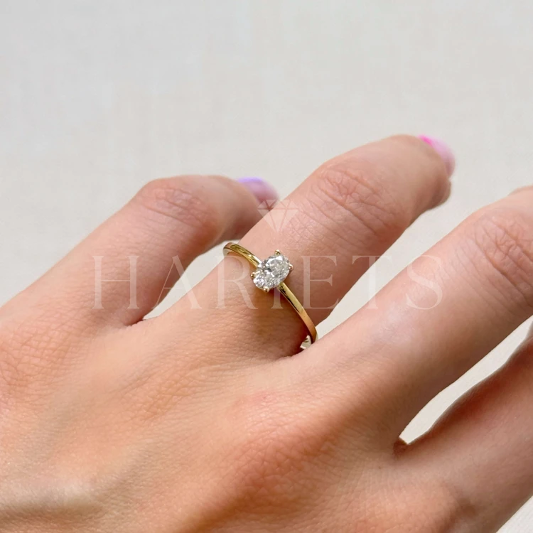 bague-fiancailles-petit-moissanite-0-5ct-taille-ovale-au-doigt-cote-or-jaune-gracelet-hariets.jpg