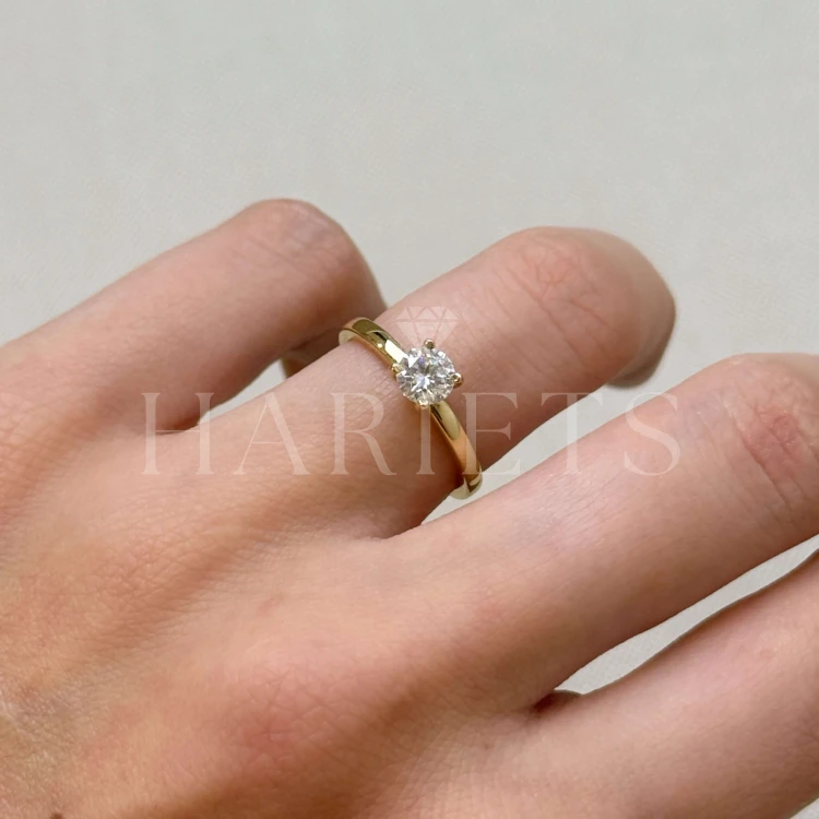 bague-fiancailles-flare-moissanite-0-05ct-taille-brillant-sur-doigt-or-jaune-hariets.jpg