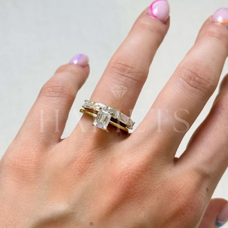 bague-avec-cinq-moissanites-2ct-taille-éméraude-sur-le-doigt-ensemble-inspiration-or-jaune-esmera-hariets