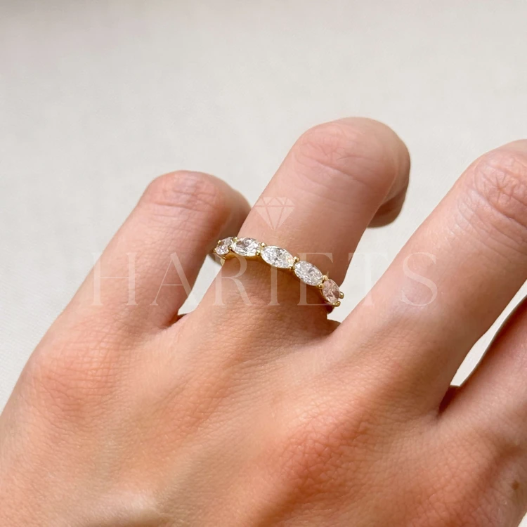 bague-avec-cinq-moissanites-1-5ct-taille-ovale-sur-le-doigt-gros-plan-or-jaune-ovalia-hariets