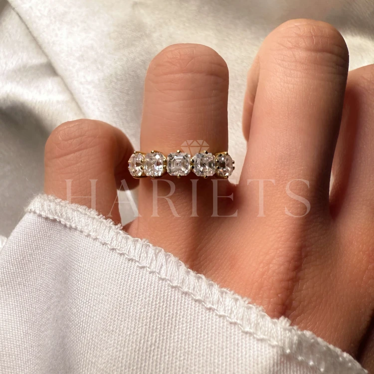 bague-avec-cinq-moissanites-taille-asscher-sur-le-doigt-gros-plan-or-jaune-lidia-hariets