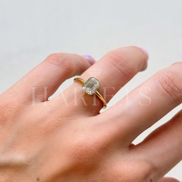 bague-de-fiancailles-bezel-diamant-laboratoire-1ct-taille-emeraude-sur-la-main-or-jaune-stellar-hariets