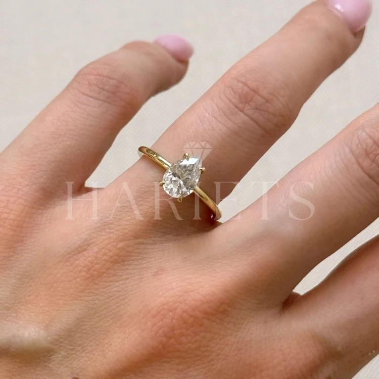 bague-de-fiançailles-solitaire-lumiere-diamant-de-laboratoire-1-5ct-poire-or-jaune-au-doigt-hariets.jpg