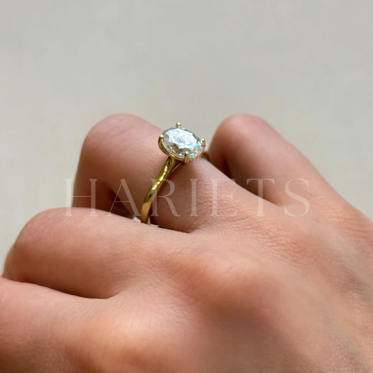 bague-de-fiancailles-solitaire-moissanite-2ct-taille-ovale-or-jaune-portee-au-doigt-vue-laterale-noelle-hariets.jpg