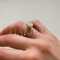 bague-de-fiancailles-solitaire-moissanite-2ct-taille-ovale-hidden-halo-or-jaune-portee-au-doigt-vue-laterale-noelle-hariets.jpg