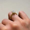 bague-de-fiancailles-solitaire-moissanite-2ct-taille-ovale-hidden-halo-or-jaune-portee-au-doigt-vue-de-face-noelle-hariets.jpg