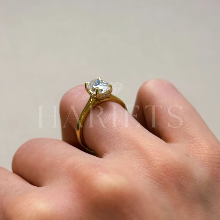 bague-de-fiancailles-solitaire-moissanite-2ct-taille-ovale-hidden-halo-or-jaune-portee-au-doigt-vue-de-face-noelle-hariets.jpg