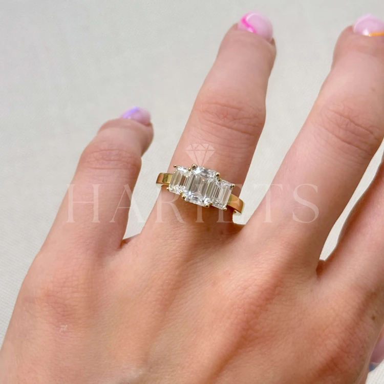 bague-de-fiancailles-trinity-moissanite-3ct-taille-emeraude-au-doigt-or-jaune-envy-hariets.jpg