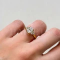 bague-de-fiancailles-trinity-moissanite-1ct-taille-radiant-au-doigt-gros-plan-or-jaune-legacy-hariets.jpg
