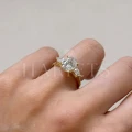 bague-fiancailles-trinity-seraphina-moissanite-2ct-taille-ovale-centrale-cote-sur-doigt-or-jaune-hariets.jpg