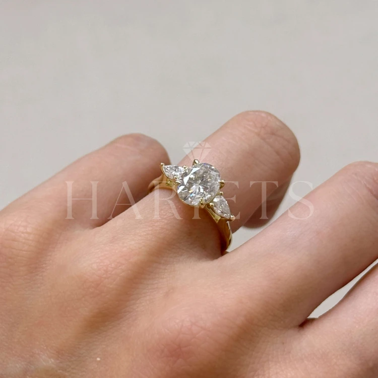 bague-fiancailles-trinity-seraphina-moissanite-2ct-taille-ovale-centrale-cote-sur-doigt-or-jaune-hariets.jpg